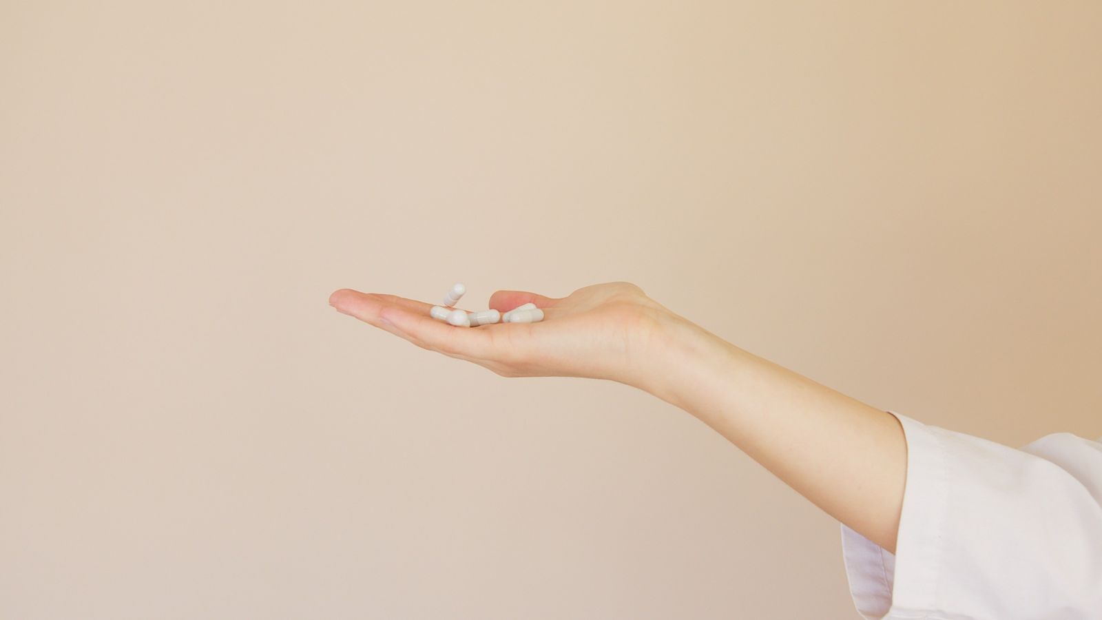 White pills in person's hand