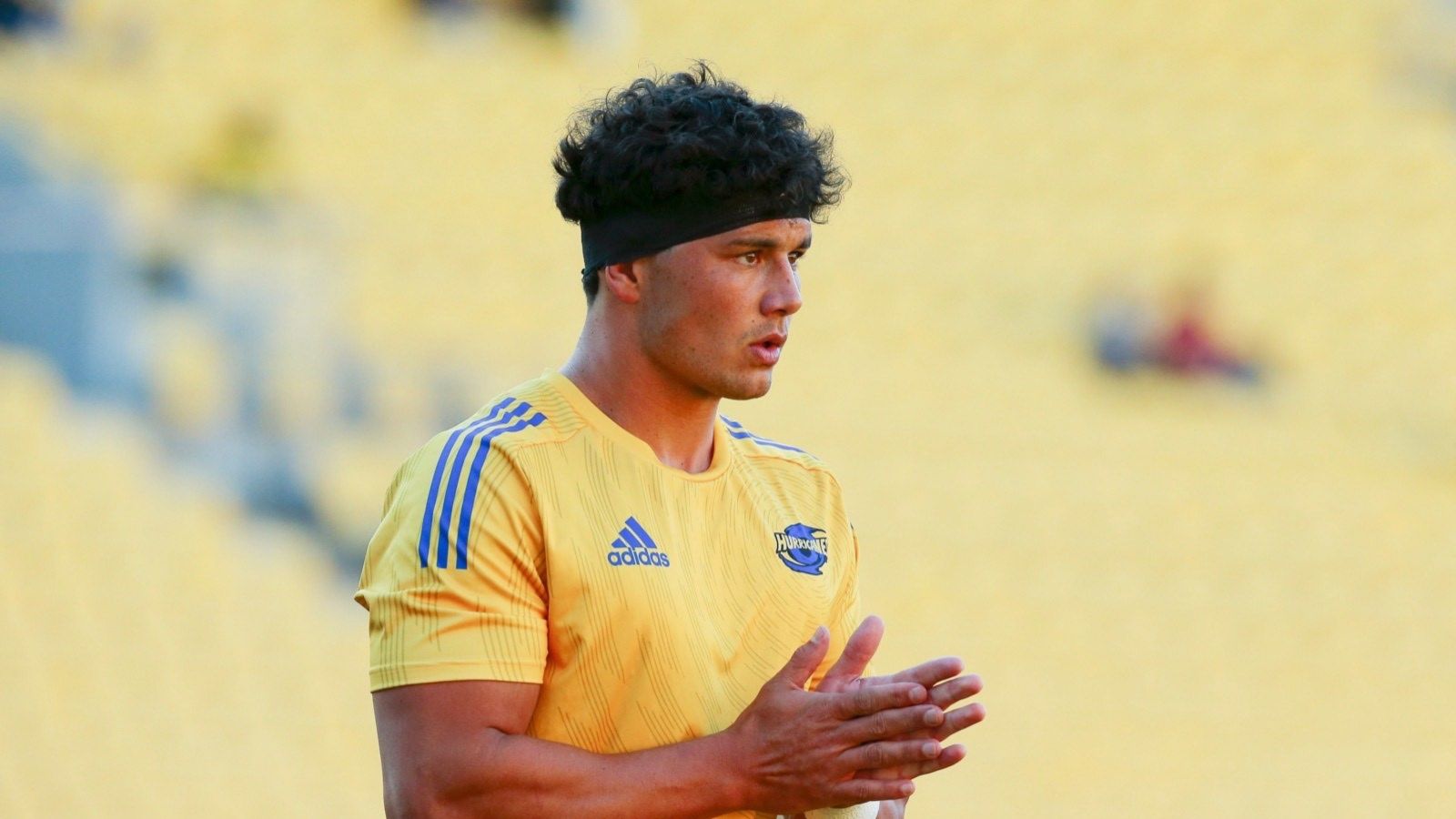 A man wearing a yellow sports shirt. He appears to be an athlete participating in a sports game.