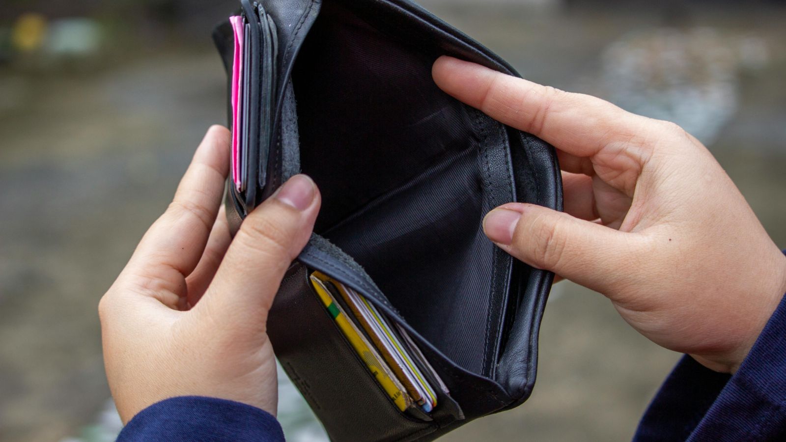 Person looking in empty wallet 