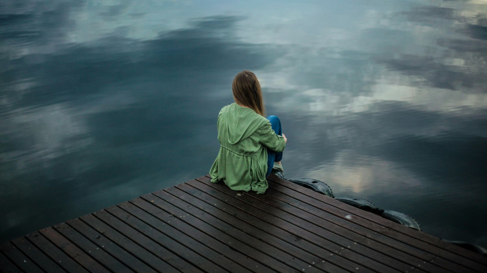 Woman sitting on deck with back to camera