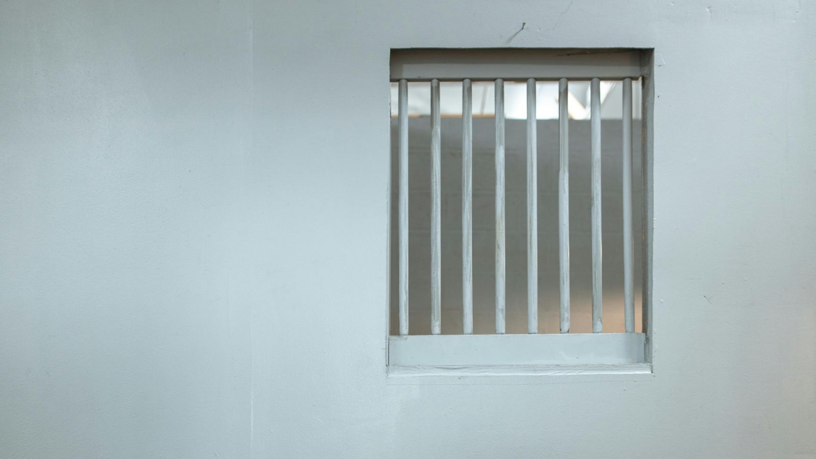 Prison cell window White steel bar window in a white wall