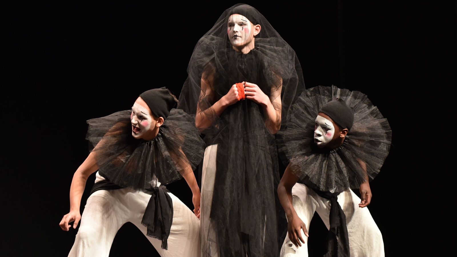 Three boys in white face paint and eerie costuming