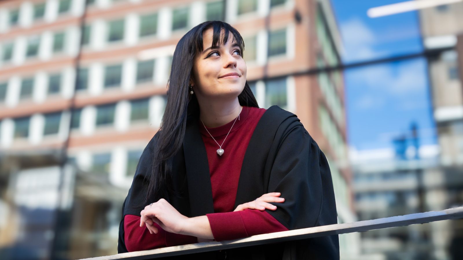 Abi Connelly poses in graduate gear in front of building