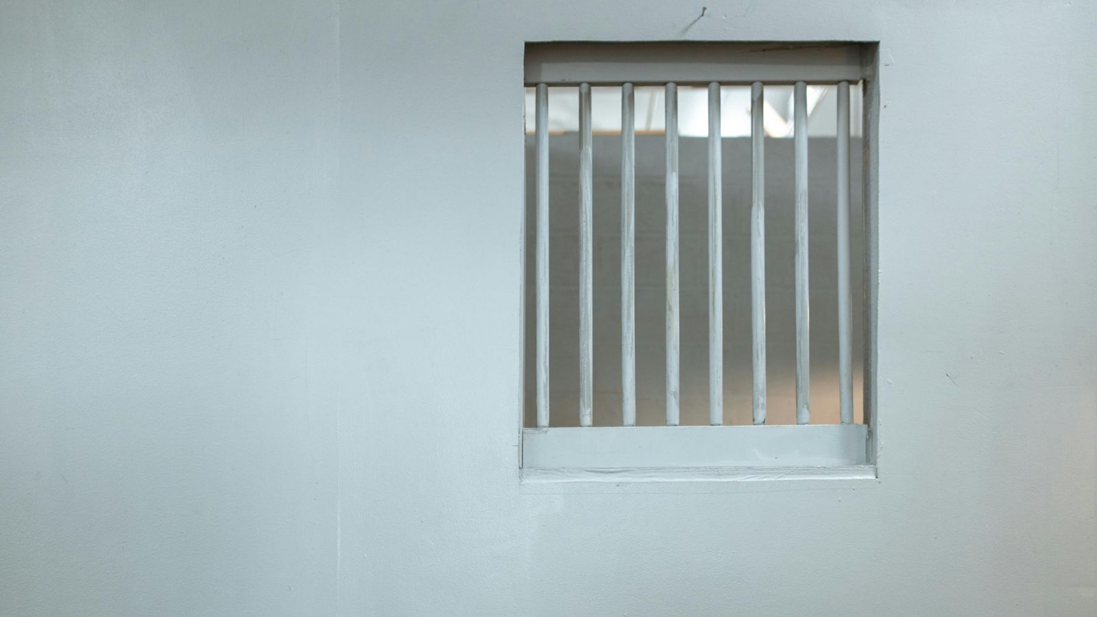 White bars on a window in a concrete wall 