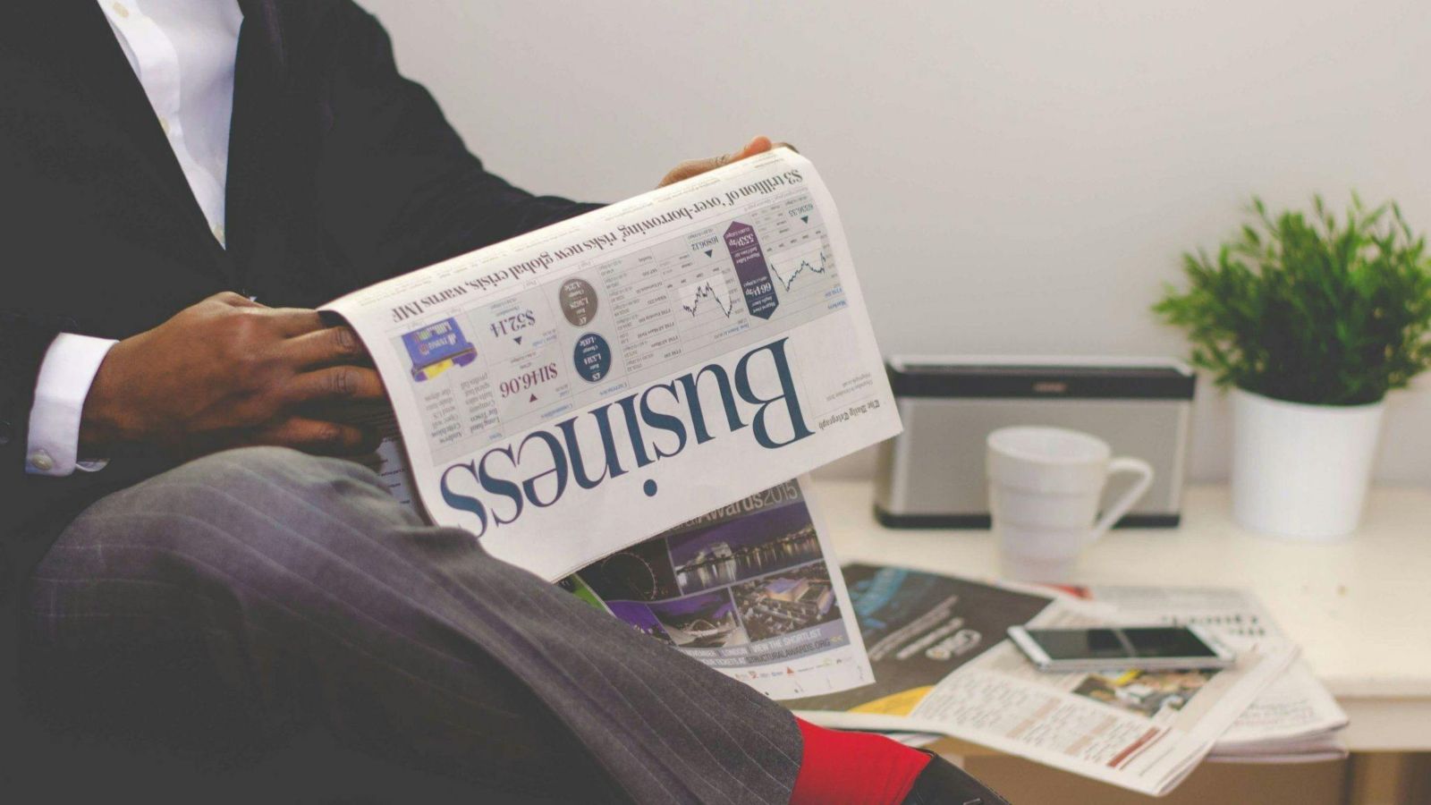 Person reading business pages in newspaper 