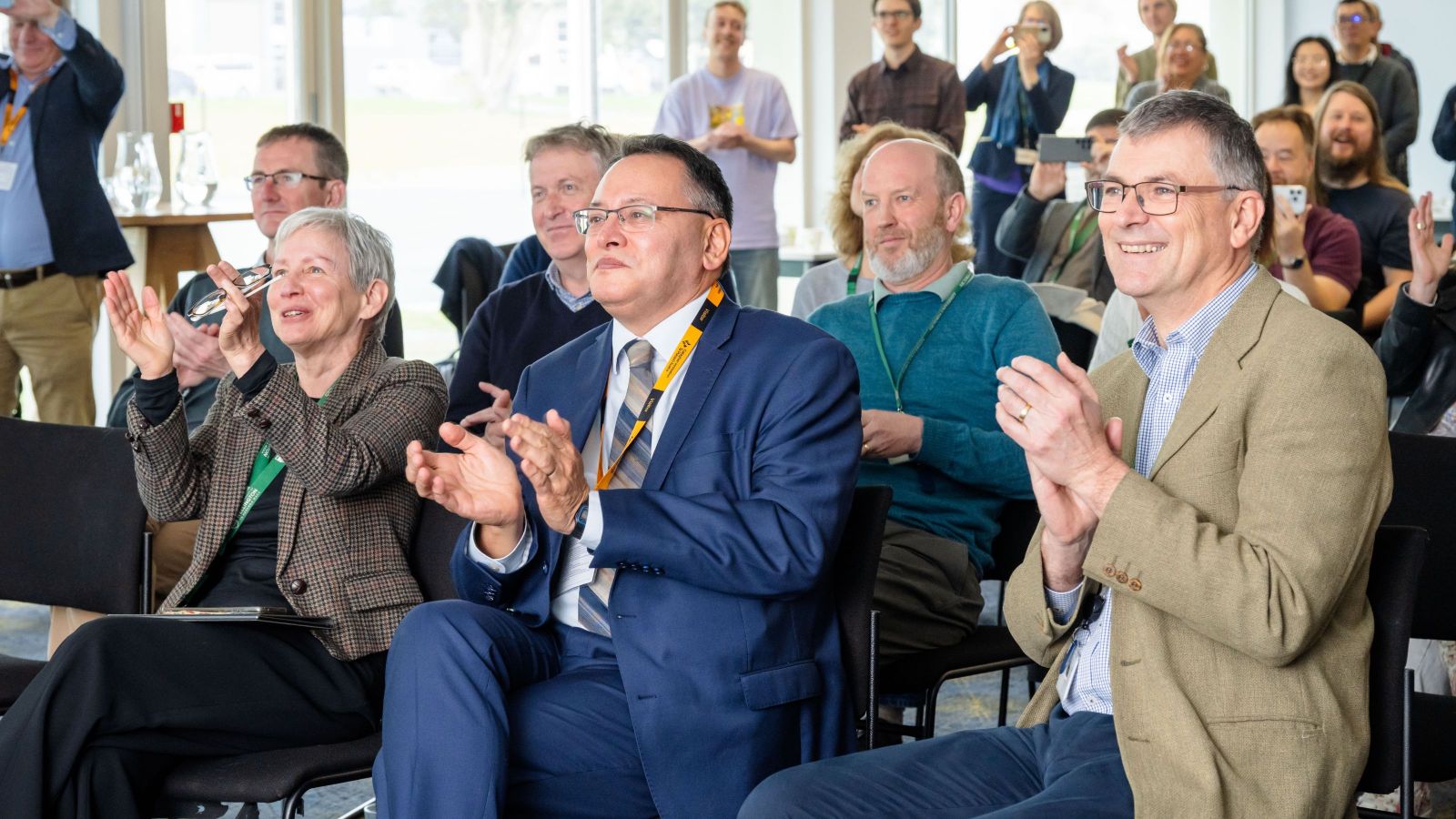 a large group of people clapping as the rocket launched