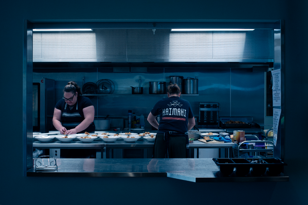A couple of people in a kitchen