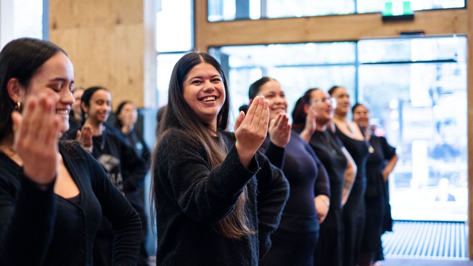 Group of smiling students doing kapa haka