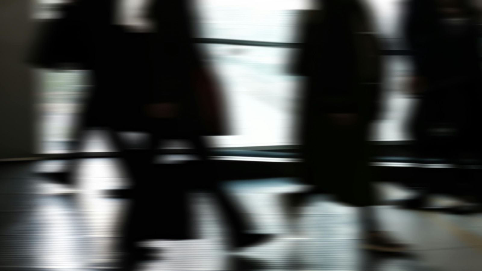 Silhouettes of people walking on street 