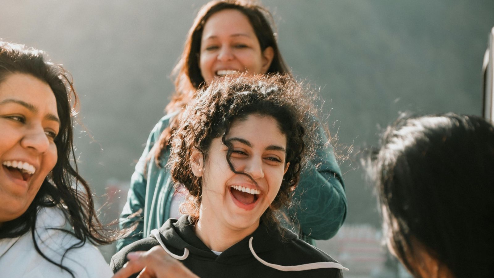 Group of four women talking and laughing 