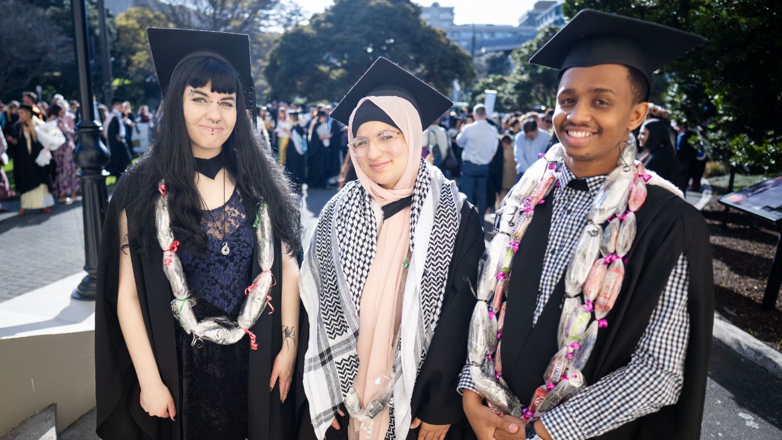Ngā Hoe a Kupe Pathfinder Scholarship recipients Nia Road, Fatima Alsaeed, and Abdirizak Mohamed at the graduation parade.