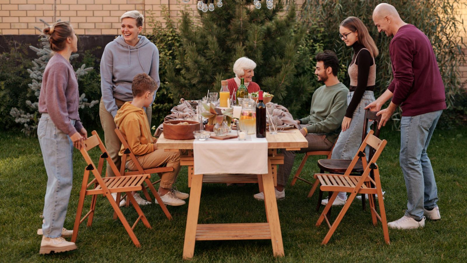 Extended family around an outdoor table eating a meal 
