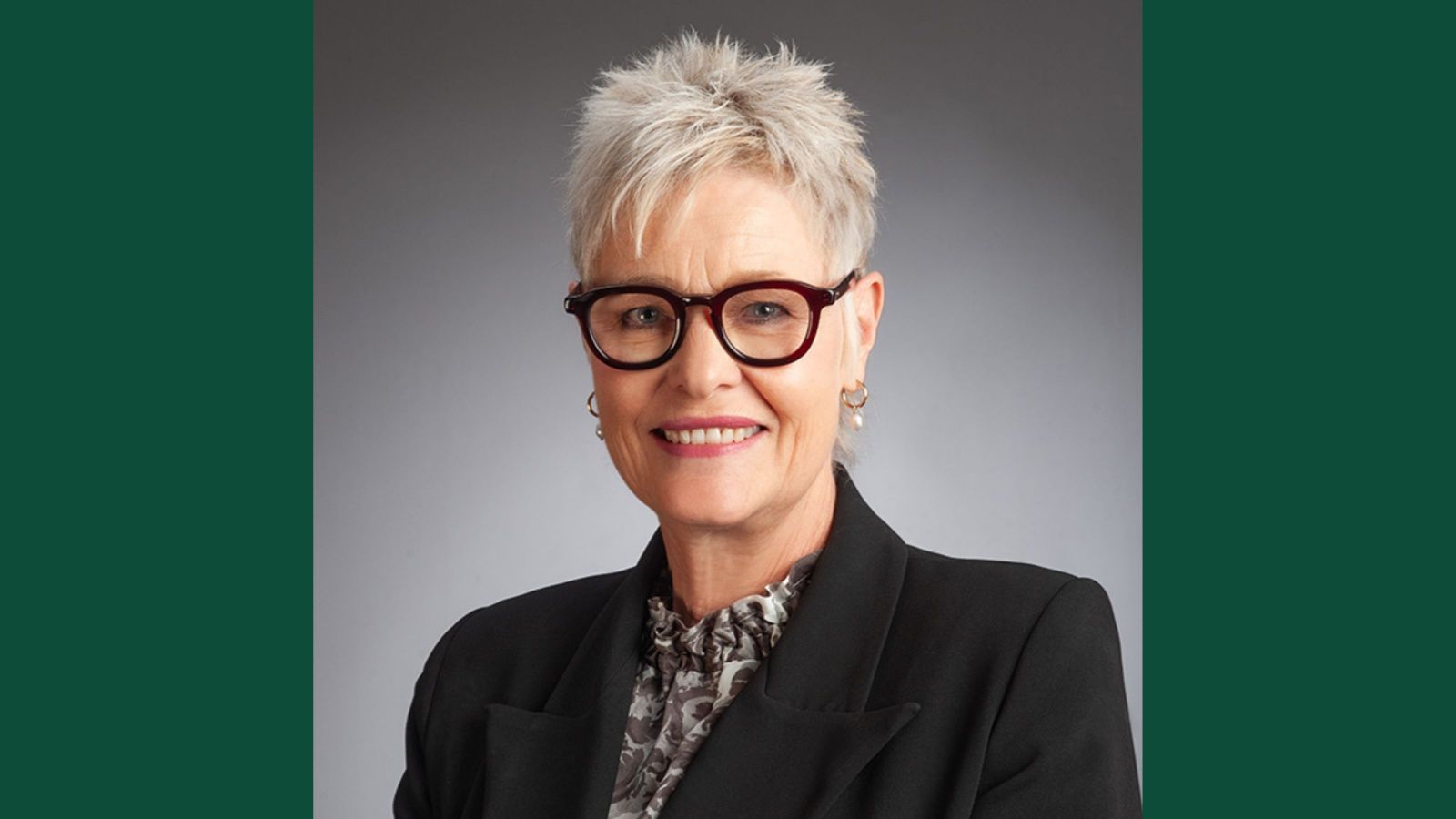woman with short blond hair and heavy rimmed glasses