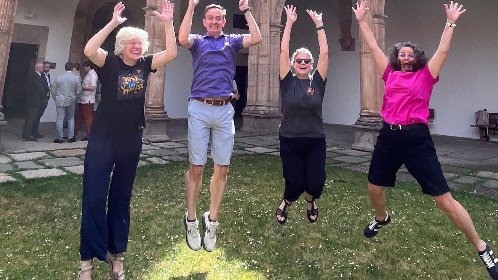 four people jumping for joy with arms stretch above their heads and happy expressions