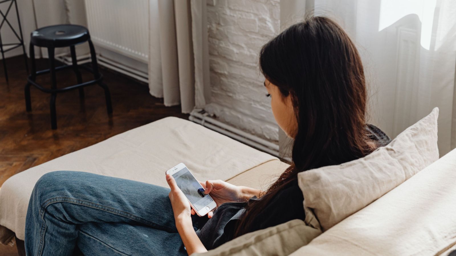 Young person sitting on couch and looking at phone