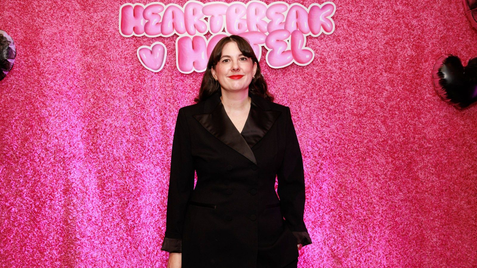 Eleanor Bishop standing for photo in front of pink wall