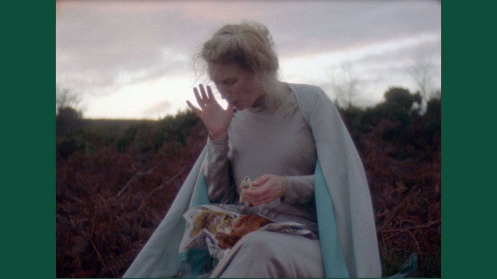 Woman wearing 1800s clothing, eating chicken on the moors