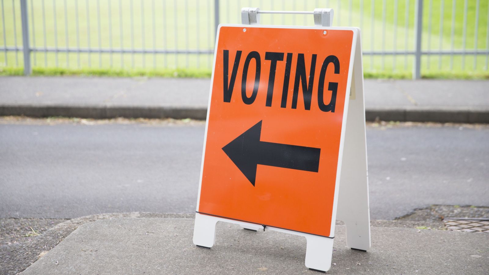 Voting sign outside on pavement 