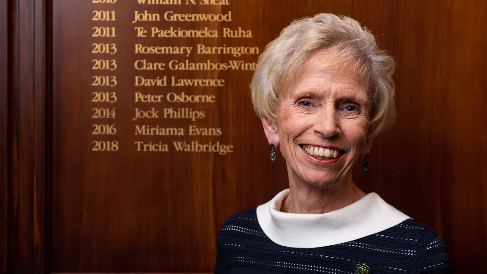 Tricia Walbridge in front of her name on the Hunter Fellow board