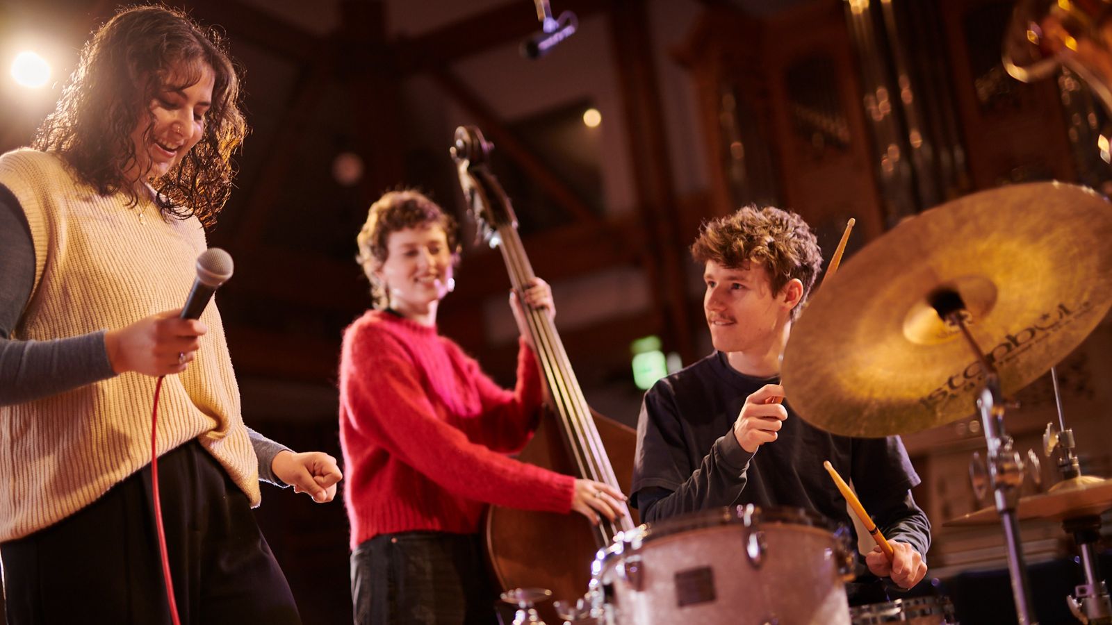 Three NZSM students playing on stage together.