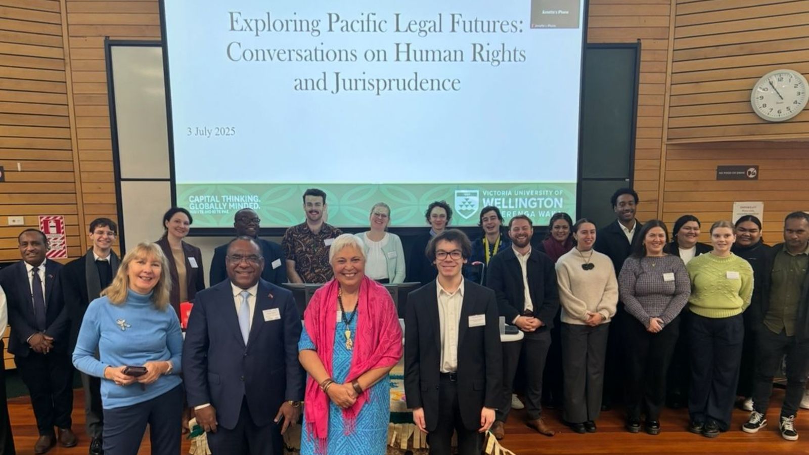 Attendees at the Symposium gather at the lecture theatre podium for a photo, including the Hon Luamanuvao Dame Winnie Laban