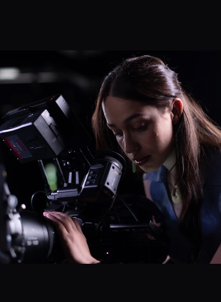 Photo of Claudia Puti Holmstead-morris looking into a large film camera