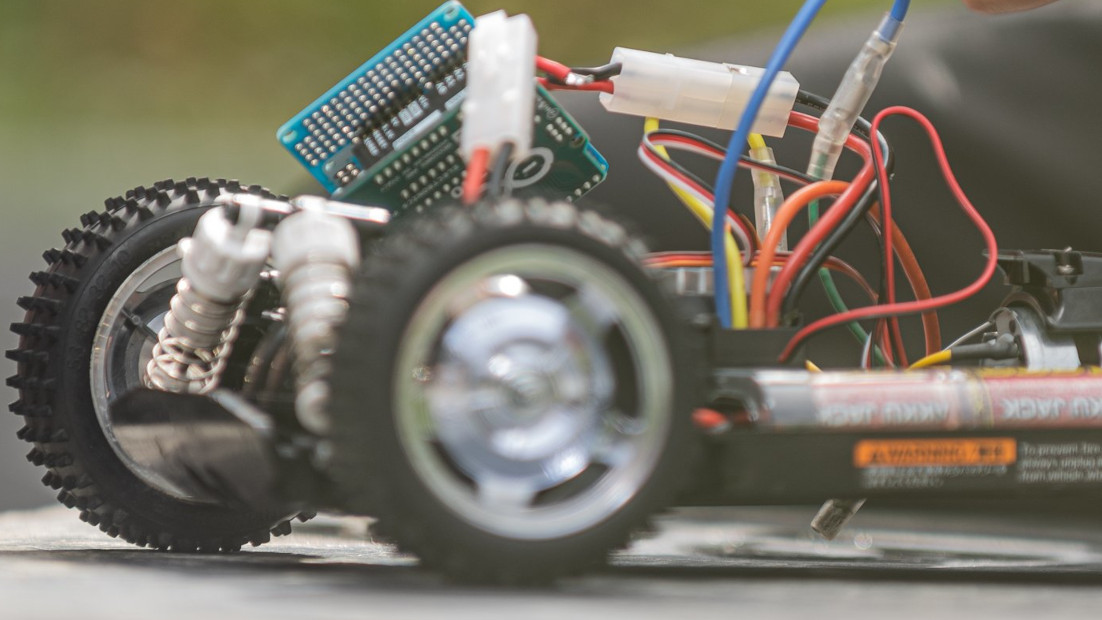 Forward section of a radio-controlled car, partially assembled with a circuit board and wiring visible.