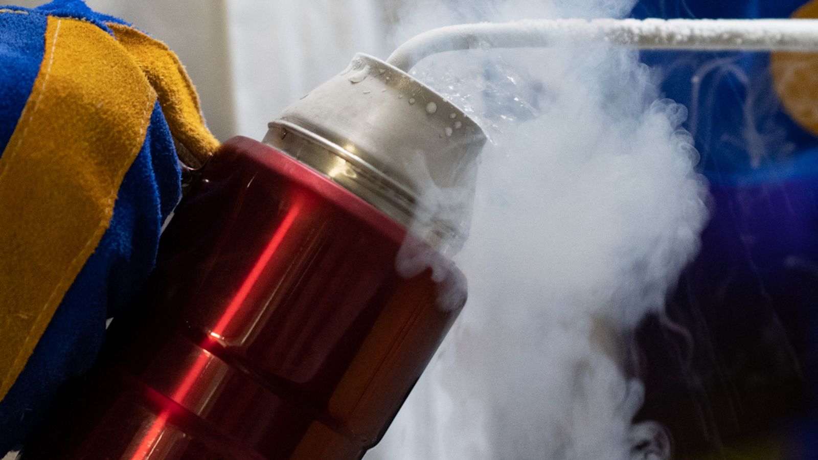 	Alt text Thermos flask being filled with smoking chemical, blue-gloved hands are visible
