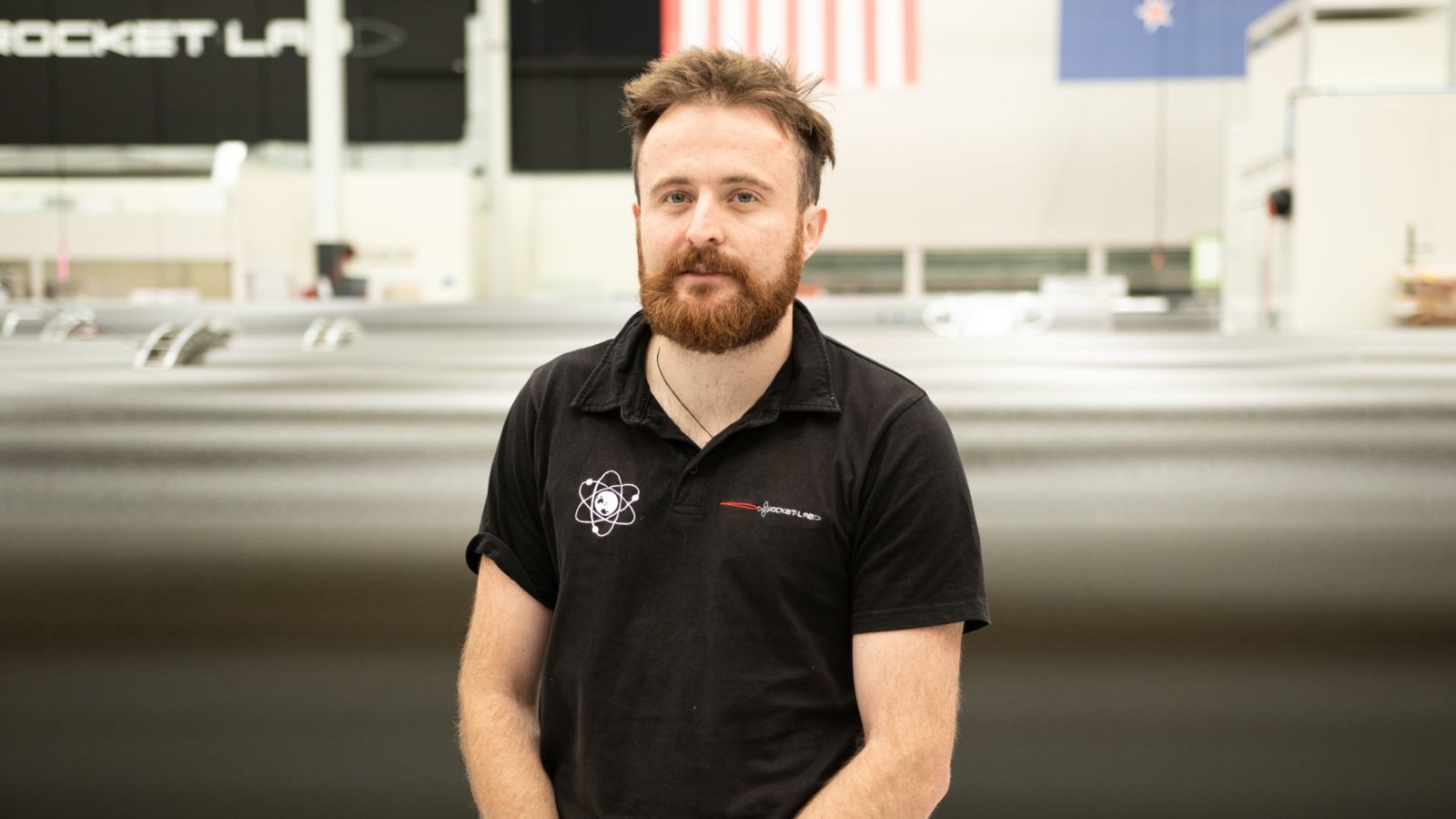 Portrait of Harry Warring standing in front of his workplace, Rocket Lab
