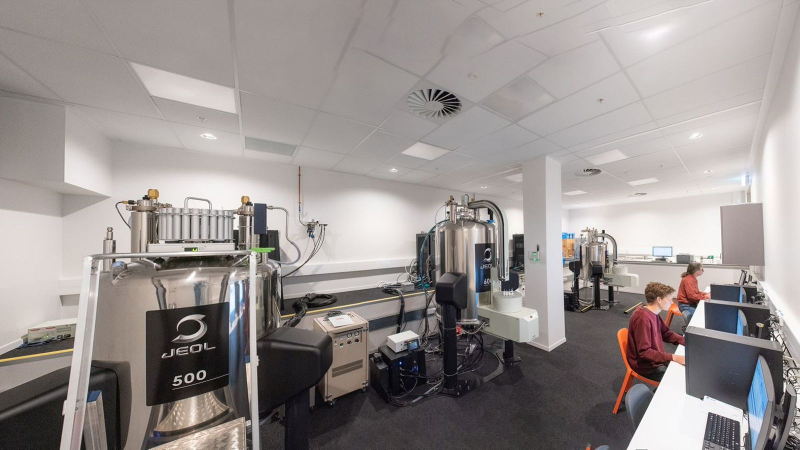 NMR spectrometer room with two people working at computers