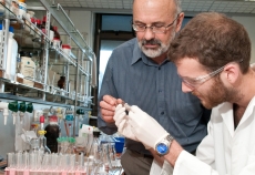 Two researchers look at a sample in a lab.