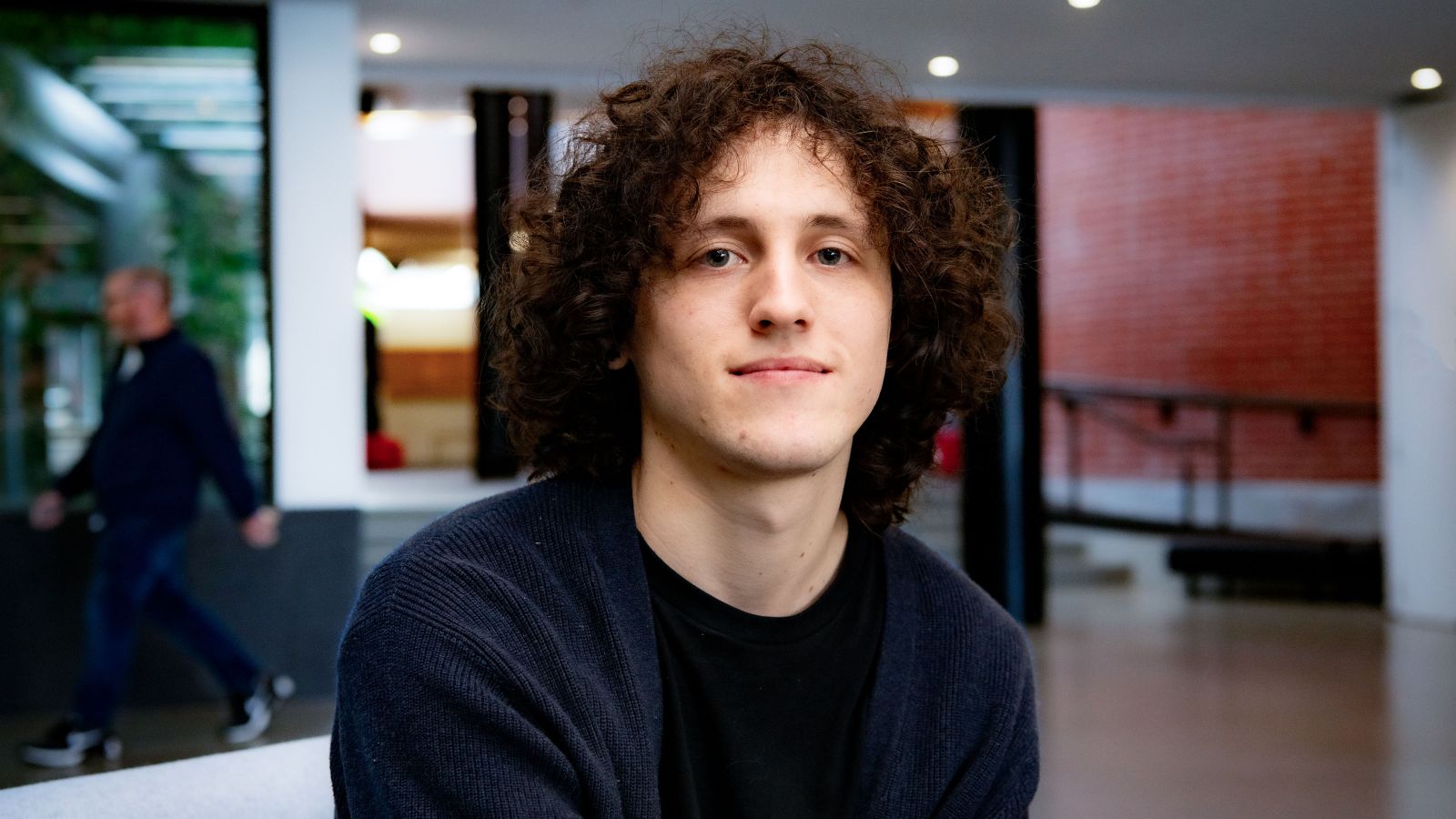 Ryan Thompson, with curly and voluminous hair, smiling.