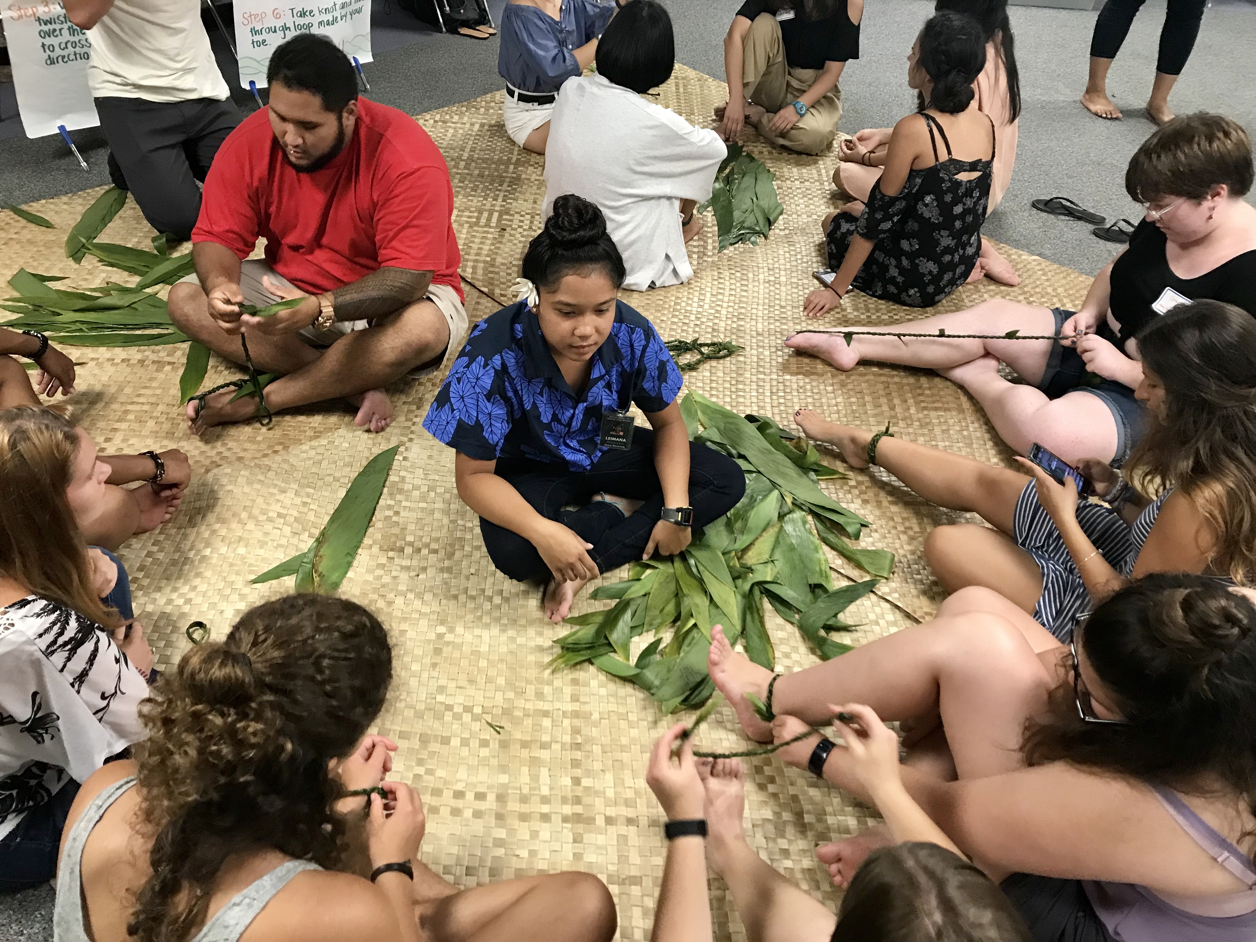 Image of people weaving leaves