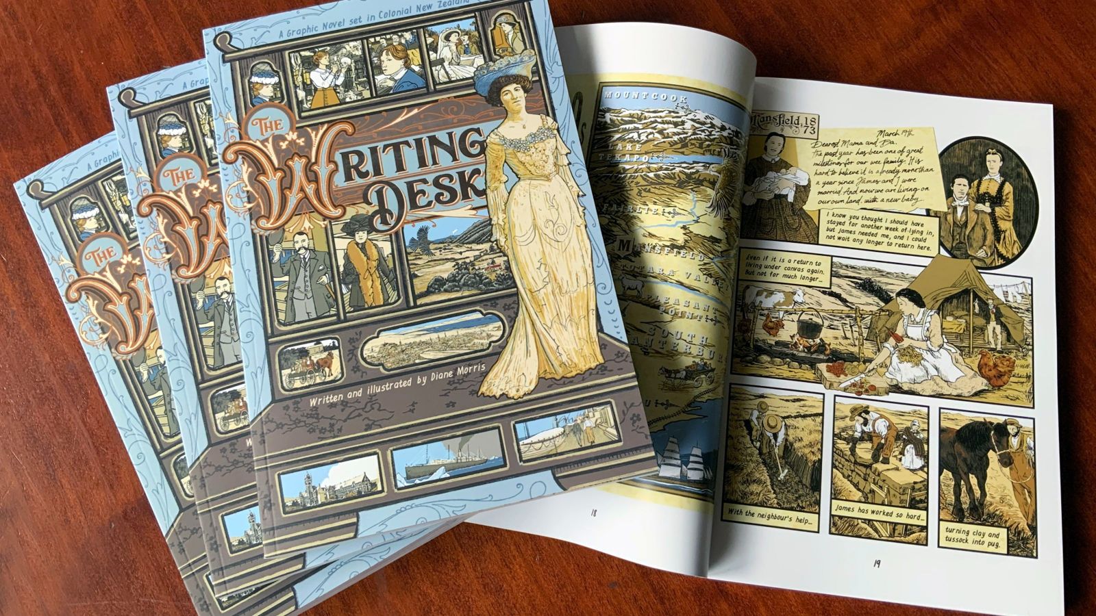 A top-down image of The Writing Desk front cover and inside page, showing characters in period dress in settler Aotearoa.