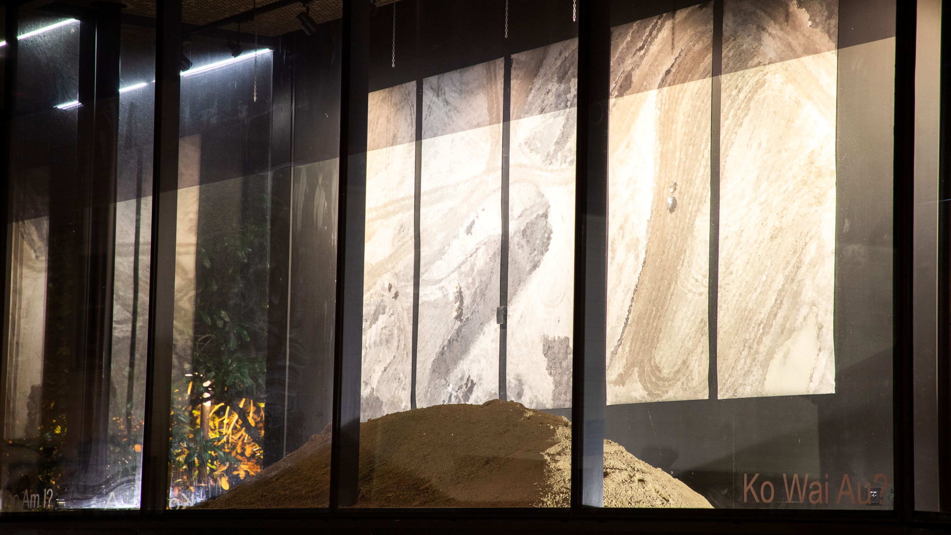 image of soil and artworks seen through glass window