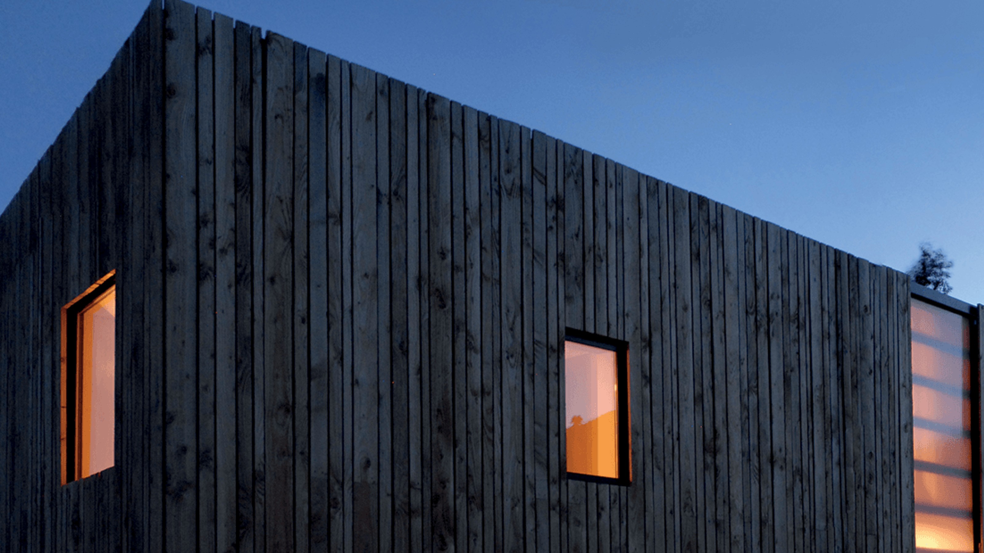 Sun-bleached modern wooden house at dusk 
